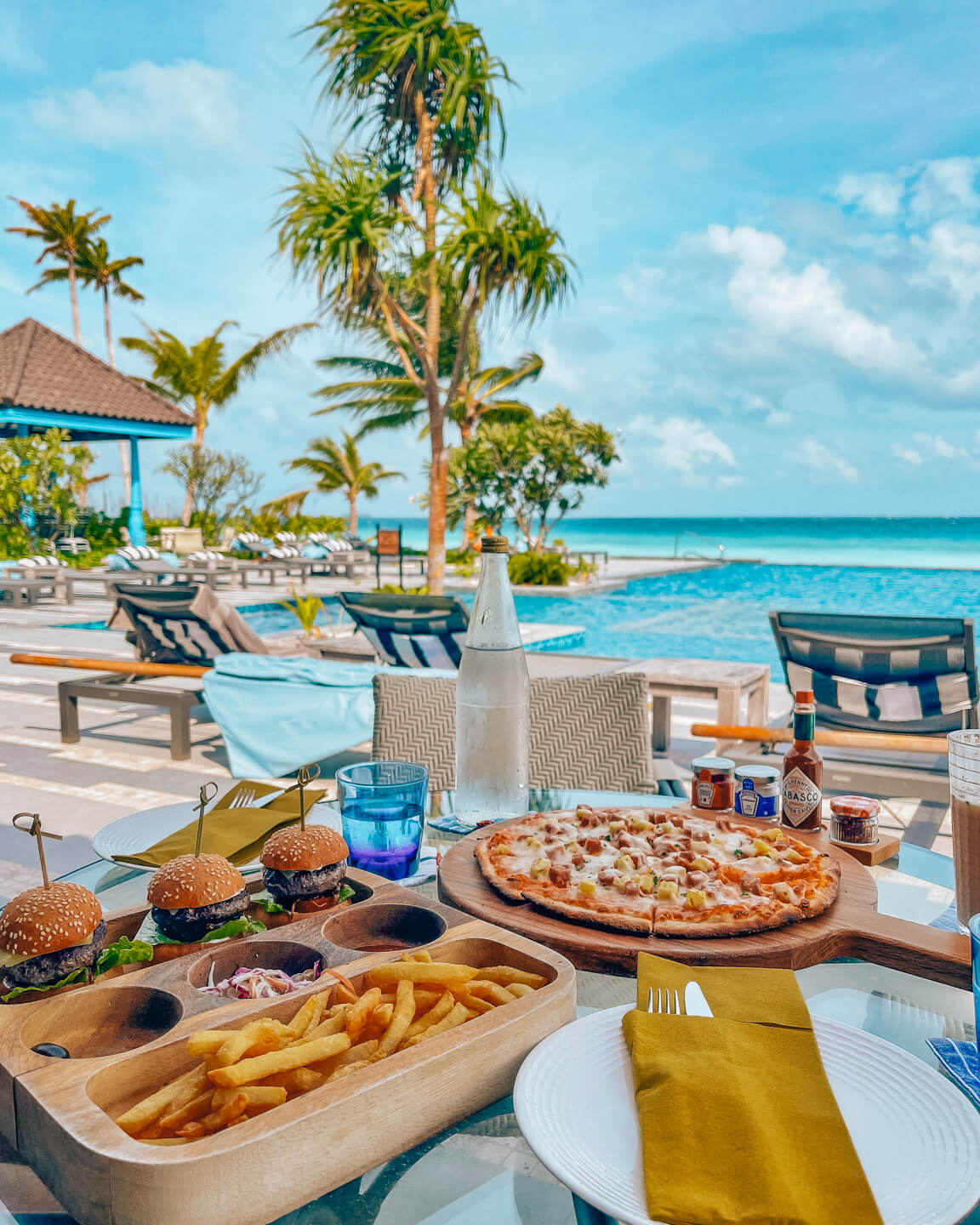 mini hamburguesas y pizza para el almuerzo en el bar de la piscina del SAii Lagoon Maldives