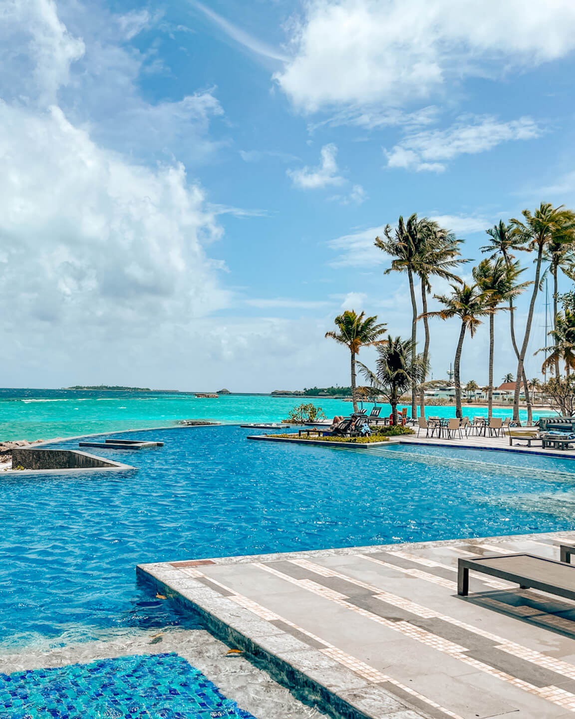 piscina principal con vista al mar y palmeras del hotel SAii Lagoon Maldives