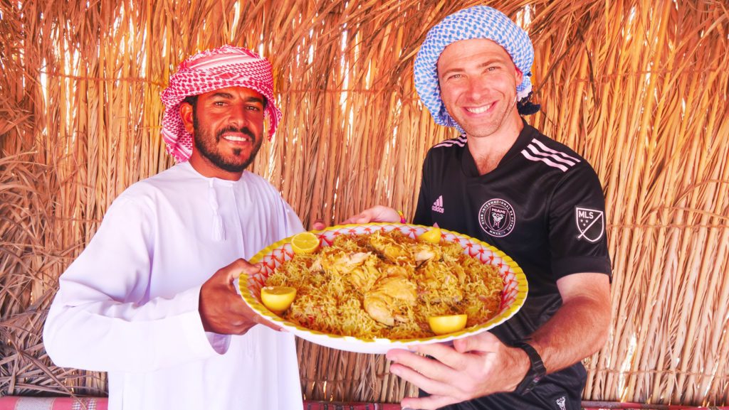 Sosteniendo un plato de Kabsa con mi anfitrión y guía beduino